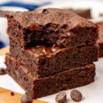 square image of stacked keto brownies on parchment paper