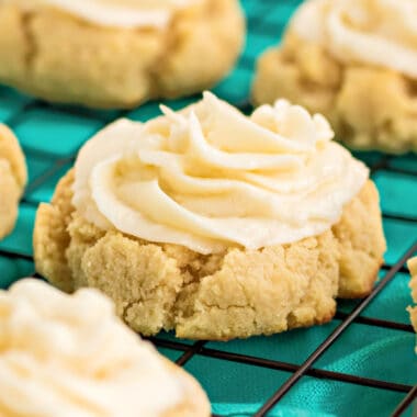 square close up image of keto cake mix cookies with buttercream frosting on a wire rack