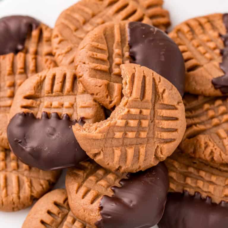 square image of regular and chocolate dipped keto peanut butter cookies on a plate