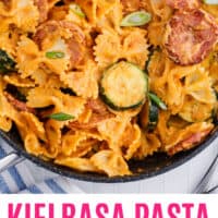 kielbasa pasta with spicy cream sauce in a skillet with recipe name at the bottom