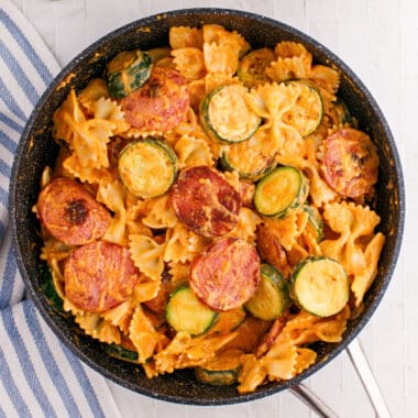 square image of kielbasa pasta with spicy cream sauce in skillet