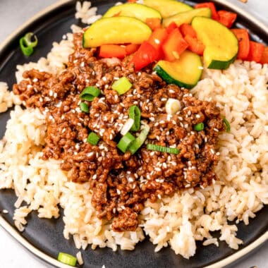 square image of korean beef bowls topped with green onions and sesame seeds