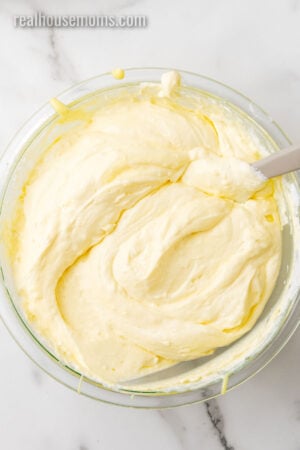 lemon mousse filling in a glass bowl with a rubber spatula
