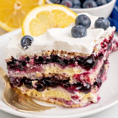square image of a slice of lemon blueberry icebox cake on a plate with a fork