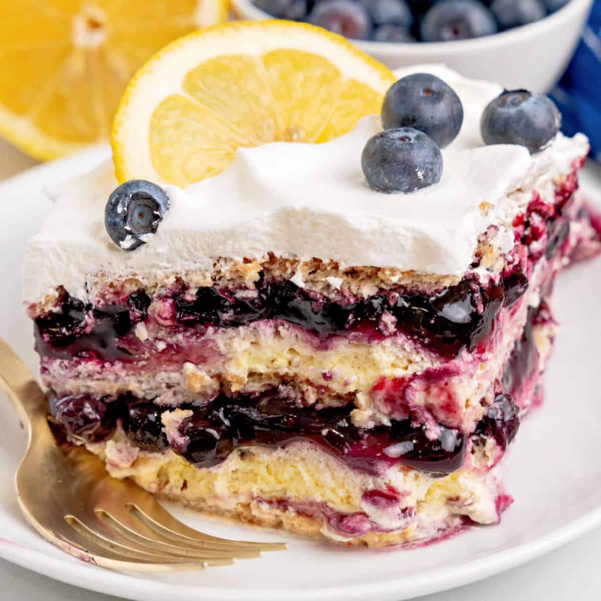 square image of a slice of lemon blueberry icebox cake on a plate with a fork