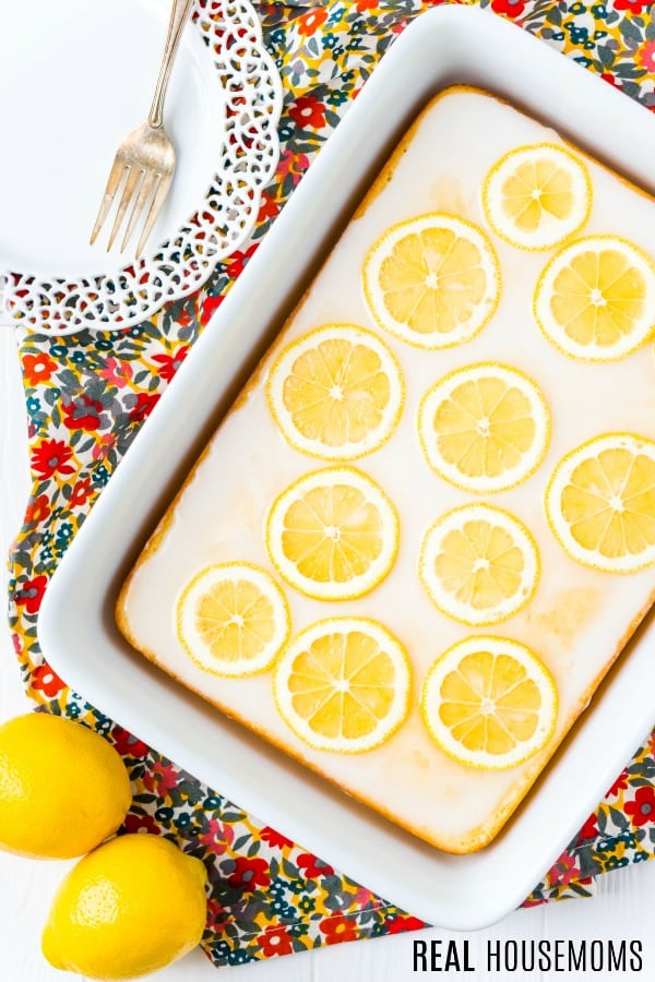 Lemon Cake in a baking dish topped with glaze and lemon slices