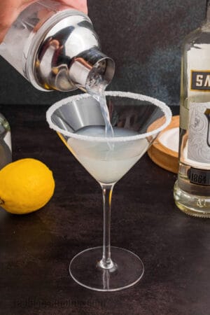 lemon drop being strained into a martini glass