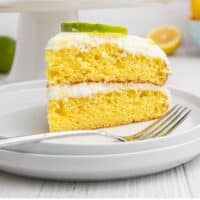 slice of lemon-lime layer cake in front of the cake with recipe name at the bottom