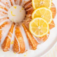 whole lemon pound cake topped with 3 lemon slices on a platter with recipe name at the bottom