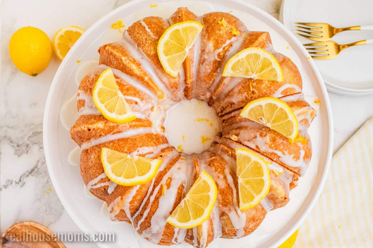 lemon pound cake topped with glaze and lemon slices on a serving plate