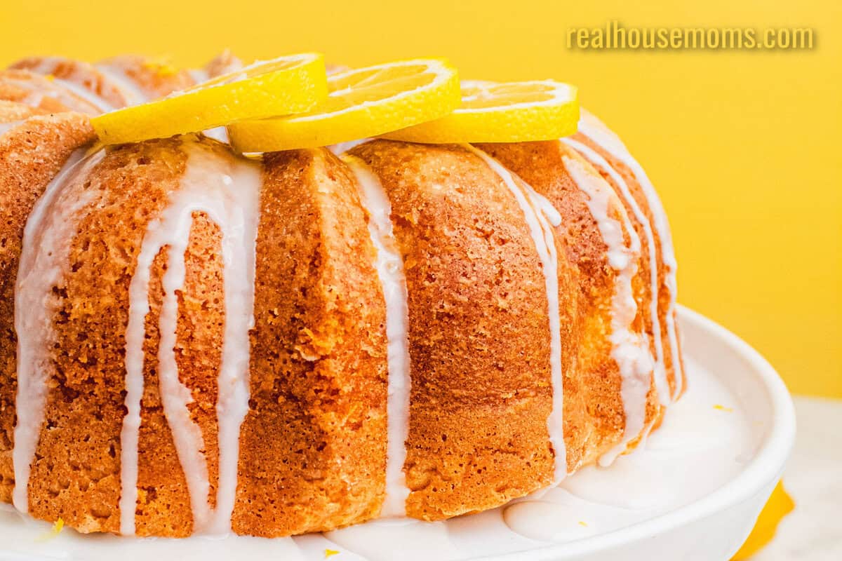 side view of lemon pound cake topped with lemon slices on a platter