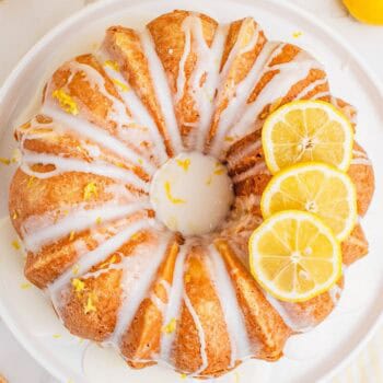 square image of lemon pound cake topped with lemon glaze and a few lemon slices