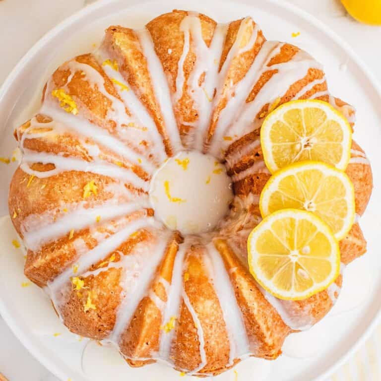 square image of lemon pound cake topped with lemon glaze and a few lemon slices