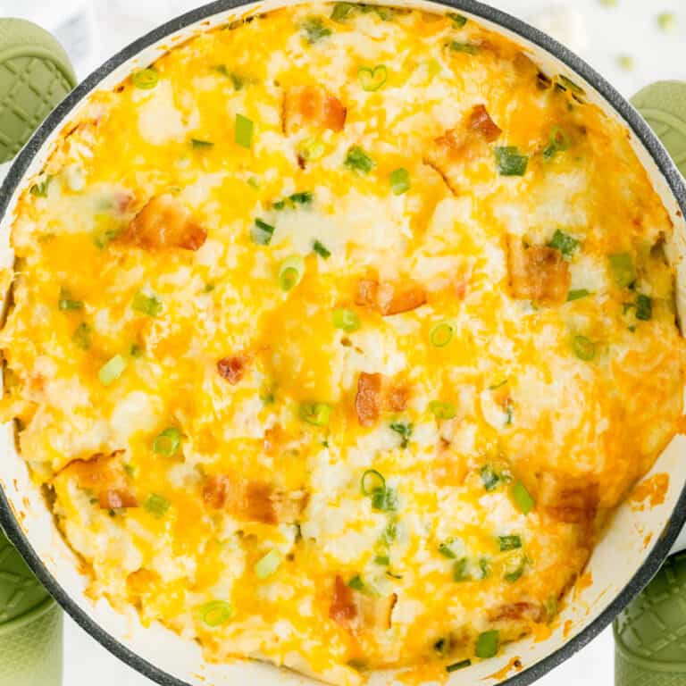 square image of loaded cauliflower casserole after baking with melted cheese on top