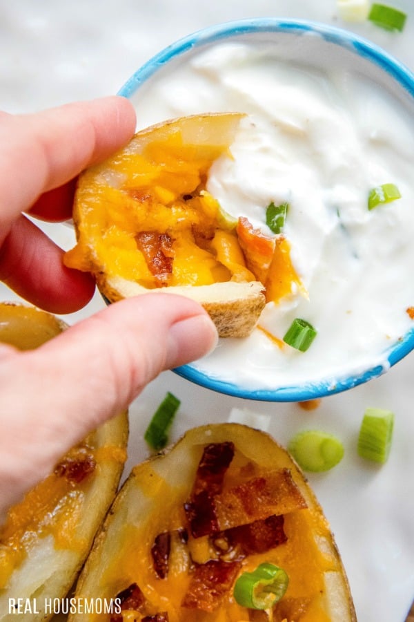 potato skin being dipped in sour cream