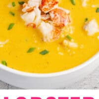 lobster bisque topped with lobster meat and chives with recipe name at the bottom