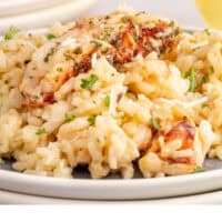 bite of lobster risotto on a fork over the plate with recipe name at the bottom