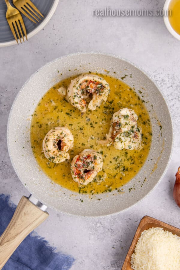 butter poached lobster tails in a skillet