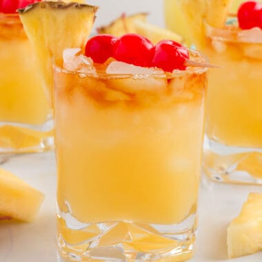 square image of mai tai cocktail with cherries and a pineapple wedge for garnish