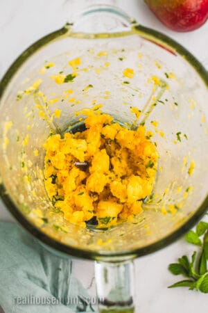 mango and mint pureed in the bottom of a blender