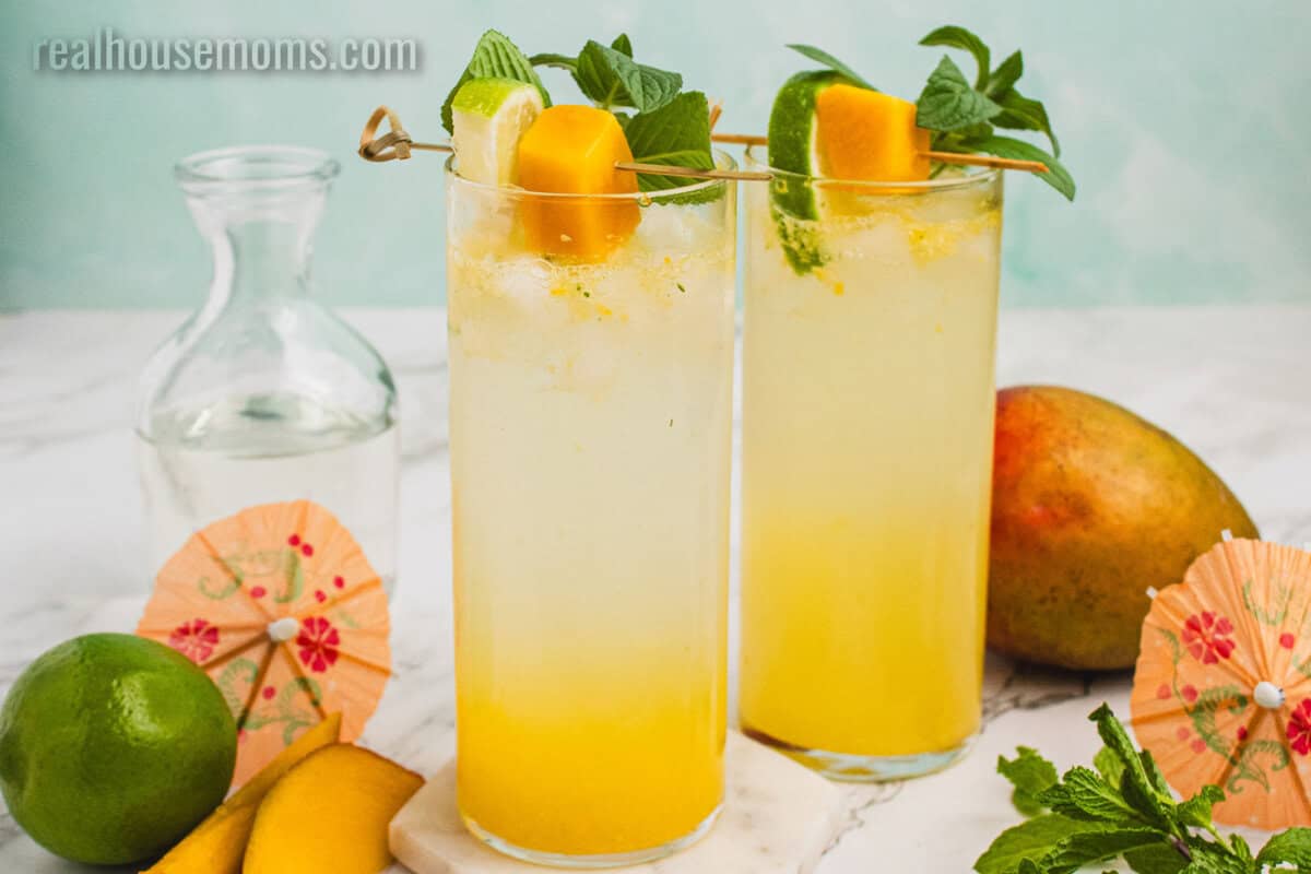 two mango mojitos next to cocktail umbrellas