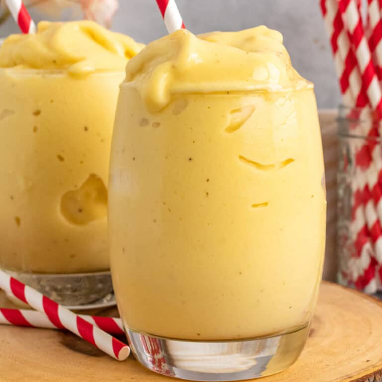square image of two glasses filled with mango pineapple smoothie