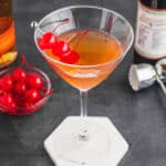 square image of a manhattan drink with cherries for garnish