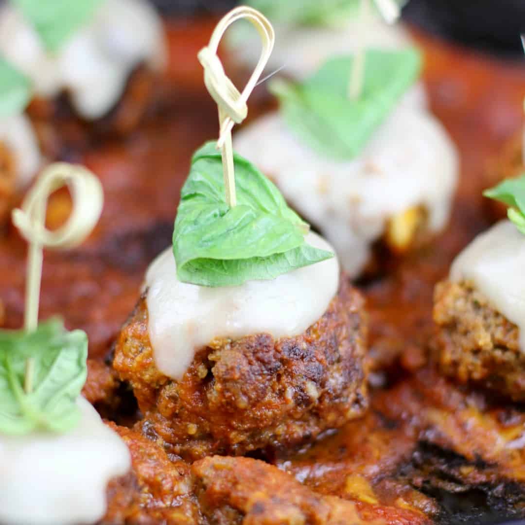 Meatball Parmesan Bites are the perfect appetizer for your next get together.  Tender meatballs, infused with garlic, breadcrumbs, and parmesan are smothered in red sauce and topped with mozzarella & basil for a burst of Italian flavor!