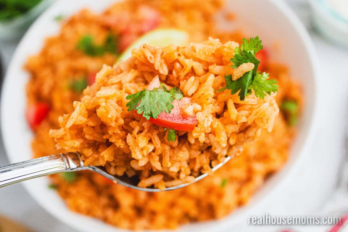 serving spoonful of mexican rice over the skillet
