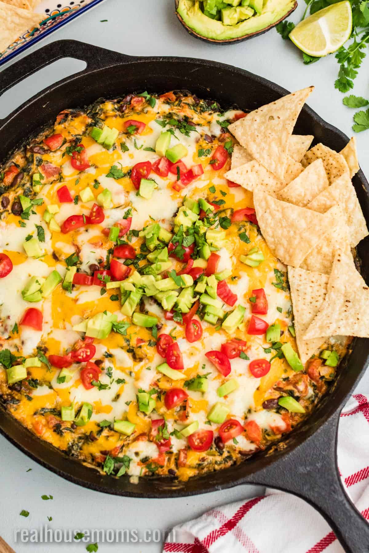 skillet of mexican spinach dip with tortilla chips on one side