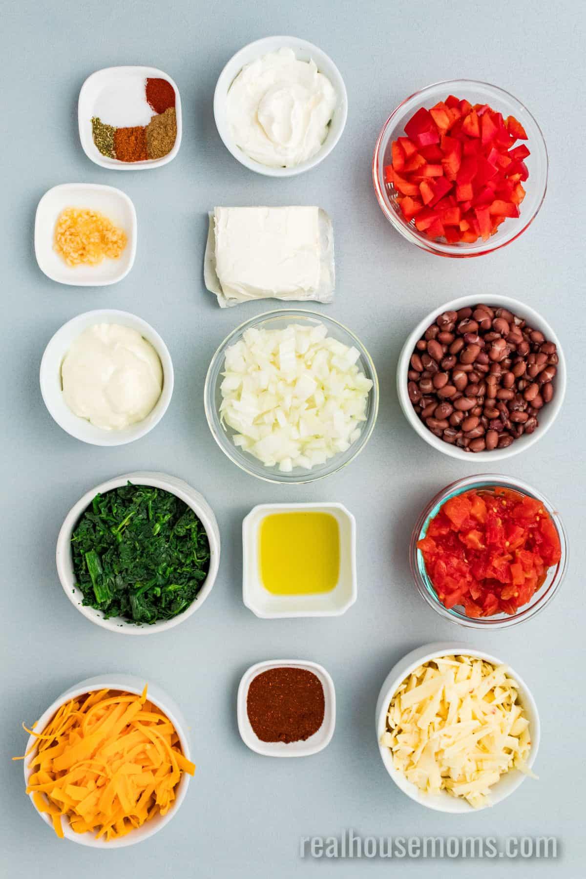 ingredients to make mexican spinach dip in bowls on a counter