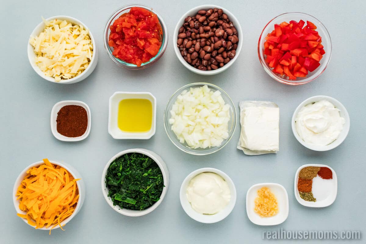 ingredients to make mexican spinach dip in bowls on a counter