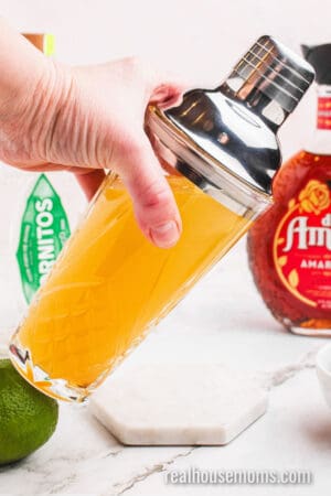 mexican sunset base being shaken with ice in a cocktail shaker