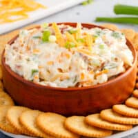 square image of a bowl of million dollar dip surrounded by crackers