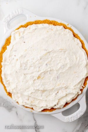 million dollar pie filling spread in a pie plate with graham cracker pie crust