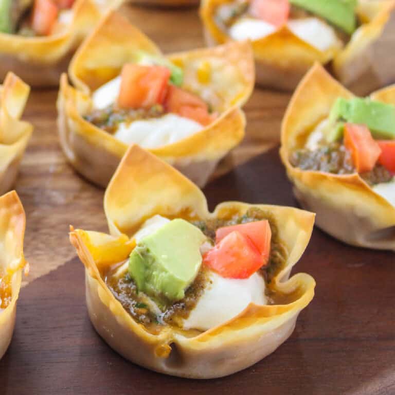 square image of mini beans dip cups on a wood board