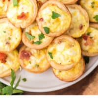mini quiche lorraine piled on a plate with recipe name at the bottom