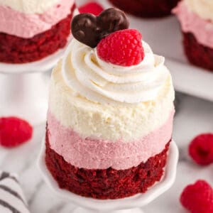sqaure image looking down at a mini raspberry mousse cake on a mini cake stand