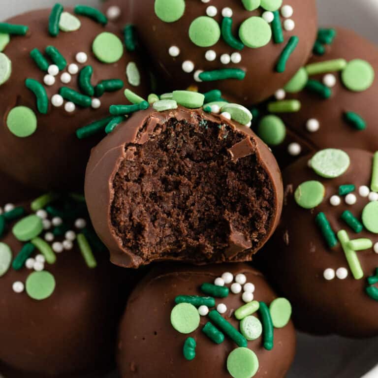 square image of mint balls in a bowl in a bite taken out of one to show filling