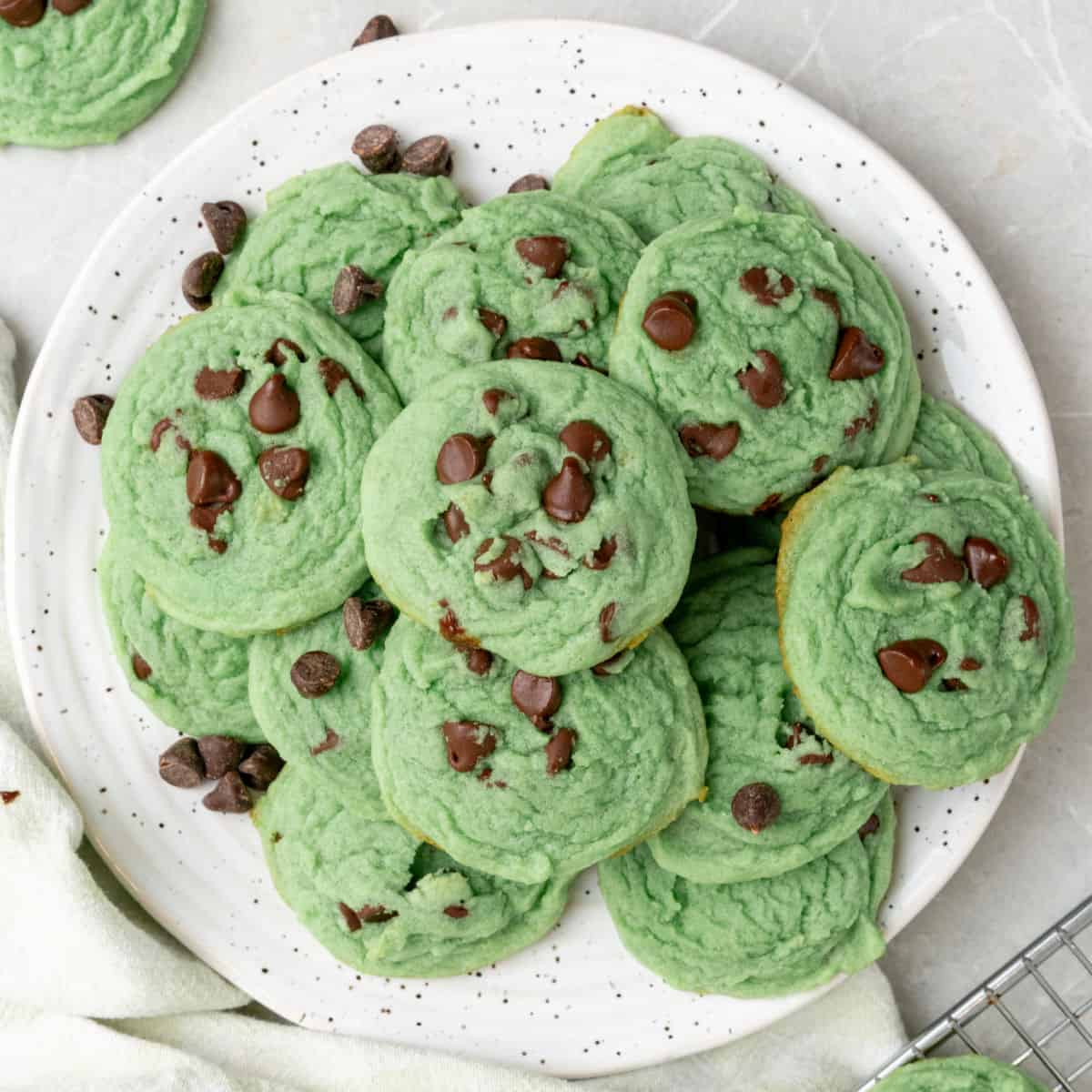 square image of mint chocolate chip cookies piled on a plate