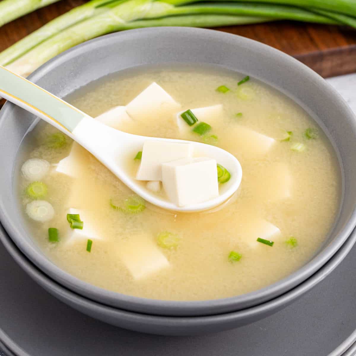 square image of a spoonful of miso soup over the bowl