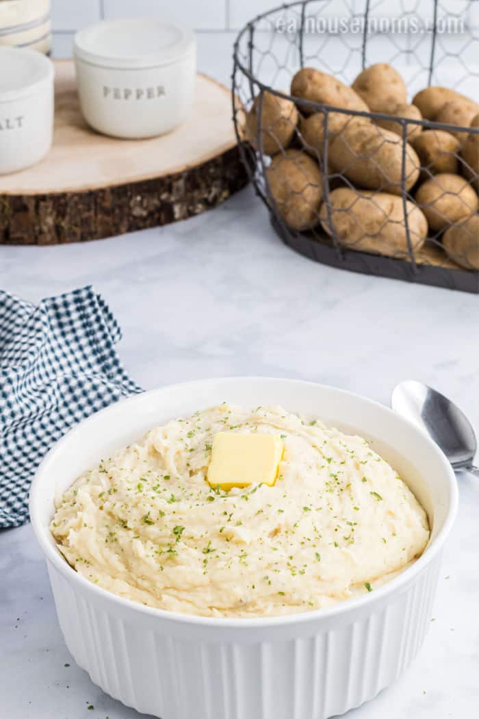 bowl of mashed potatoes with basket of russet potatoes