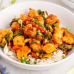 square image of Mongolian chicken over white rice in a bowl