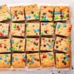 square image of monster cookie bars on parchment paper