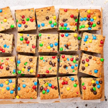 square image of monster cookie bars on parchment paper