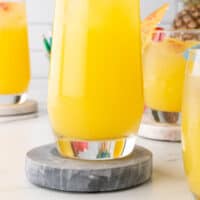 moscato pineapple punch in a tall glass with recipe name at the bottom