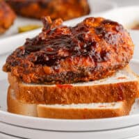 sqiare image of nashville hot chicken on two slices of white bread on a plate
