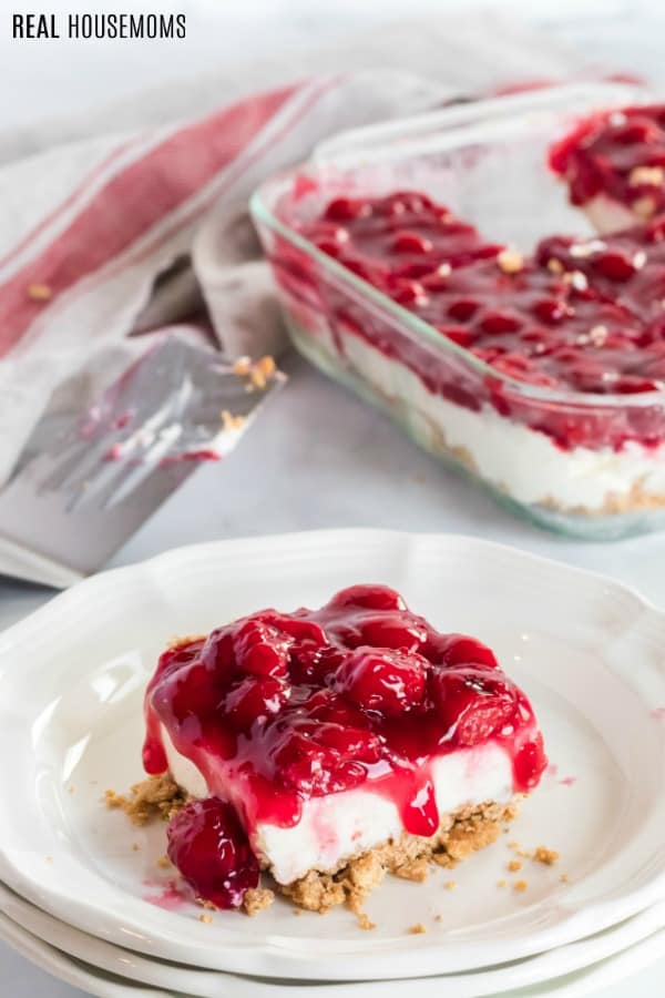 cherry cheesecake slice on a plate with pan behind it