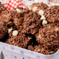 square image of no bake oatmeal cookies in a tin with chocolate chips sprinkled around