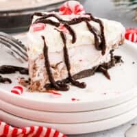 no bake peppermint pie slice on a plate in front of the pie with recipe name at the bottom